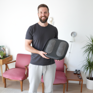Man holding a black foot massage device in a living room setting